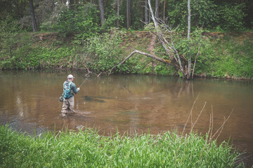 The fisherman catches with a spinning rod on the river.