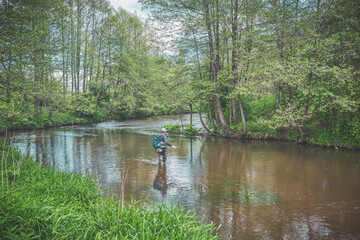 The fisherman catches with a spinning rod on the river.