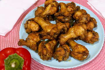 Delicious fried chicken wings on a blue plate