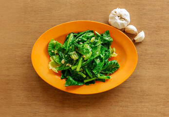 Fried Kai Lan Oyster Sauce  with fried garlic (Chinese Broccoli) on wooden background top view food