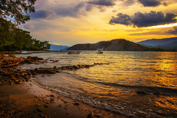 PHASELIS, TURKEY: Beautiful view from the beach to the sea and mountains in the ancient city of Phaselis at sunset.
