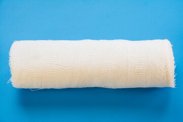 White medical bandage on blue background top view