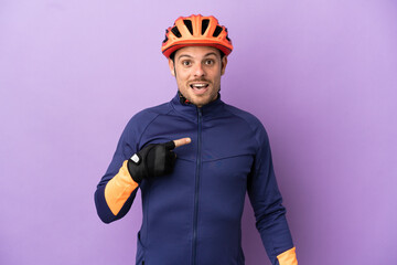 Young Brazilian cyclist man isolated on purple background with surprise facial expression