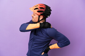 Young Brazilian cyclist man isolated on purple background suffering from pain in shoulder for having made an effort