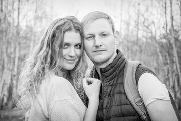 In the autumn afternoon in the forest, a young couple. Black and white photo.