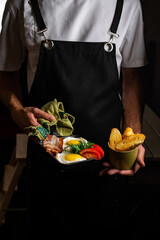 old pan in hand. fried egg, bacon, onion rings, parsley, bread - tasty Breakfast or snack. On a dark wooden out of focus table. Top view