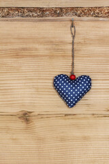 A blue handmade heart on wooden wall, copy space.