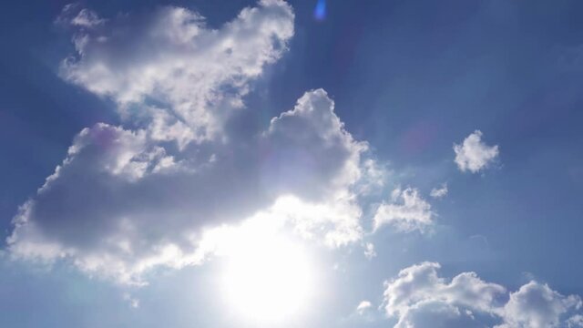 Sun light ray flare or sunbeam on blue sky n white clouds