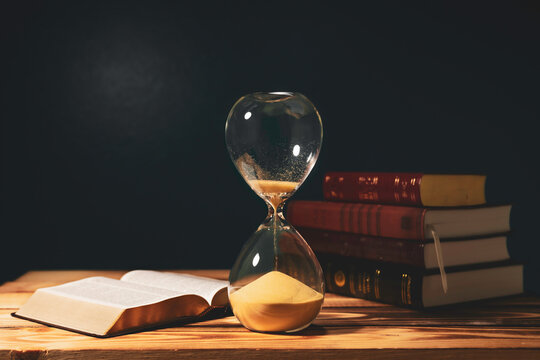 Vintage hourglass with open Bible