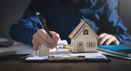 Real estate agent signing document for home loan insurance.