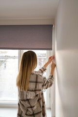 Home blinds or window curtains girl opens the window in the morning. Morning rituals