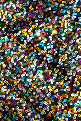 shiny fabric with multicolored sequins texture close up. sparkling scales sequins rainbow textile...