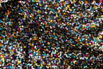 shiny fabric with multicolored sequins texture close up. sparkling scales sequins rainbow textile...