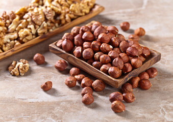 Hazelnuts and walnuts in old wooden dish
