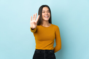 Teenager girl isolated on blue background happy and counting four with fingers