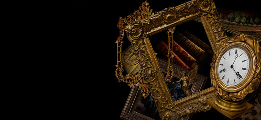 Antique still life with old carved frames, ancient books and vintage clock in a carved frame