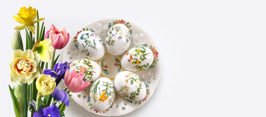 Easter postcard. Decorated eggs on a decorative plate and different flowers
