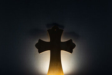 wooden cross being illuminated in the dark