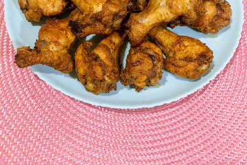 Fried chicken wings on a turquoise plate. Juicy and crispy fried chicken wings