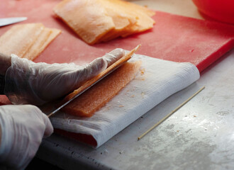 cutting red fish fillets into thin pieces