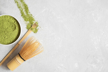 Matcha green tea powder, bamboo whisk and spoon on a gray background. Japanese drink. Tea ceremony....