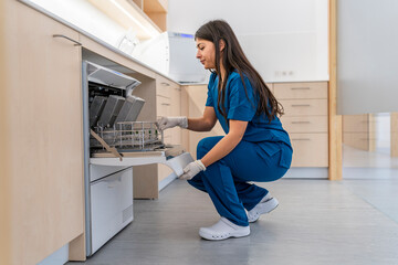 Nurse crouching checking machine for the disinfection of medical material in a hospital