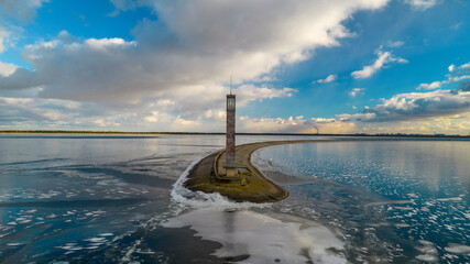 Aerial view of a pier with a lighthouse on a frozen lake