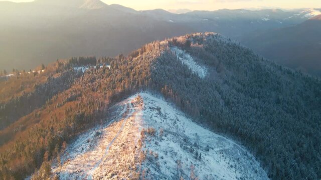 Aerial camera rises above winter mountains