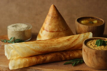 Crispy crepes made of barnyard millets and lentils. Commonly known as barnyard millet ghee roast dosa. Plated in conical shape and rolls. Served with coconut spicy condiments.
