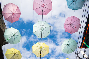 Colorful umbrella decorations against a cloudy sky. 