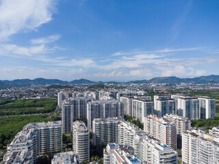 Fototapeta premium Aerial view of Jacarépagua in Rio de Janeiro, Brazil. Residential buildings and mountains in the background. Sunny day. Drone photo