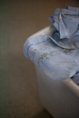 Blue sheets with flowers in the laundry basket