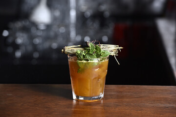 drinks tropical citrus fruits over ice, with sprigs of herbs, grants space for text in blurred...