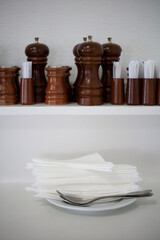 Fototapeta na wymiar Bar service with salt and pepper mills, toothpick holders and white cloth napkins