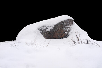 natural stone in snow isolated on black background