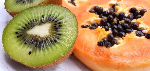 Fruit background. Juicy slicing of fruit and citrus. Bright fresh slices of kiwi and papaya. Juicy...