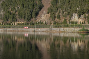 A truck, fire department truck and its reflection on water of uzungol Turkey. Translation of truck itfaiye is fire department.