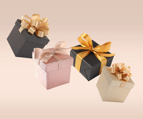 Beautifully wrapped gift boxes flying on beige background