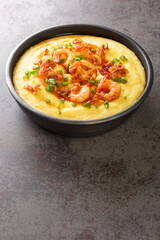 Plate with fresh tasty shrimp and grits closeup on the concrete table. Vertical