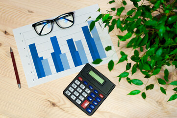 workstation of an accountant or economist, top view of the calculator, graphs, glasses and pen....
