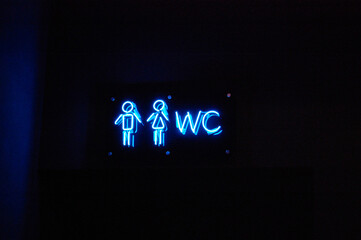 WC neon icon on dark wall.