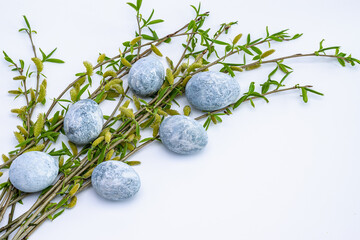 Marble Easter eggs and willow twigs on a white background. Easter greeting card.