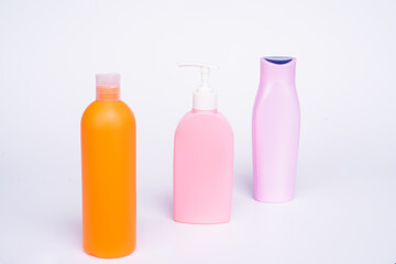 Plastic toiletry containers for liquid cosmetic products in row isolated on white, bottles