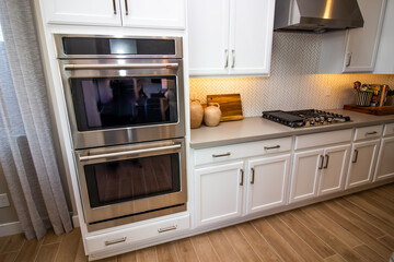 Kitchen With Stainless Steel Ovens & Range Hood, Gas Stove Top And Counter Decor