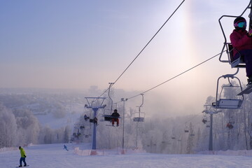 Fototapeta premium Snow-covered trees in hoarfrost at a ski resort, lift, funicular, ski lift 