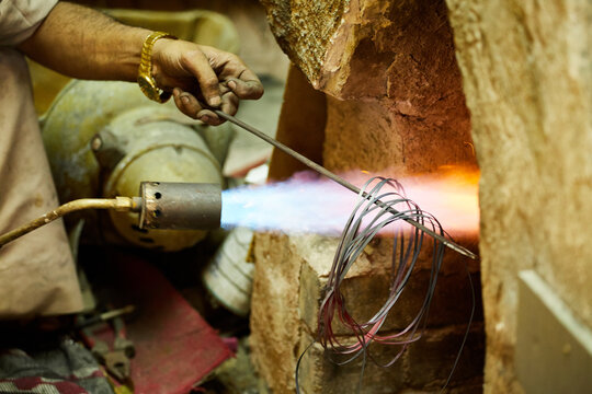 A metal craftsmen with a blowtorch