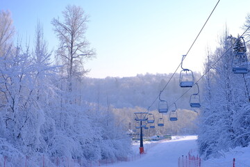 Obraz premium Snow-covered trees in hoarfrost at a ski resort, lift, funicular, ski lift 