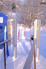 A beautiful snowman is molded from the snow, stands and waits