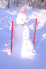A beautiful snowman is molded from the snow, stands and waits