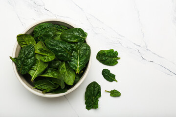 spinach leaves in a bowl on a white background top view 